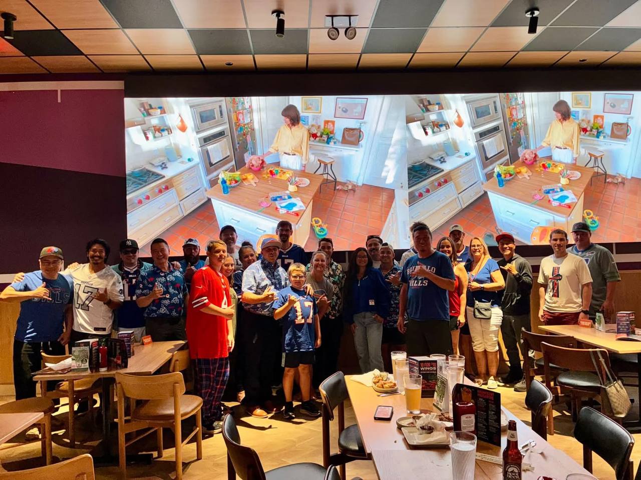 Bills Mafia Hawaii crowd at Dave & Buster's Honolulu, jerseys and flags out, watching the Bills-Lions game.
